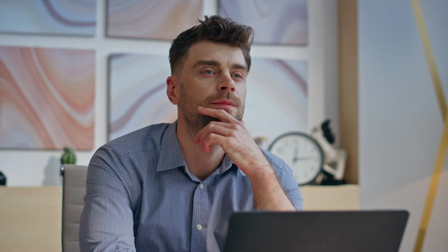 Thoughtful businessman pondering project looking distance in workplace agency office closeup. Calm male professional sitting laptop table. Friendly guy relaxing alone in cabinet. Business work concept
